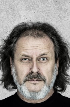 Zdjęcie przedstawia mężczyznę z włosami do ramion i siwą brodą.