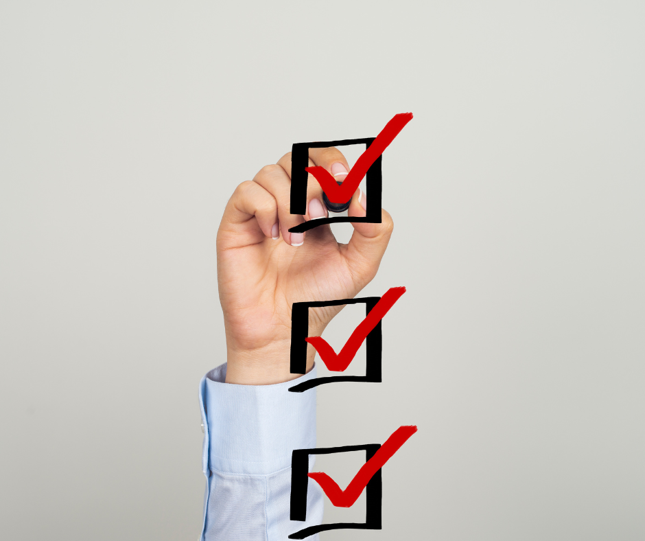 Zdjęcie przedstawia rękę człowieka, który trzyma mazak i odznacza checklistę.